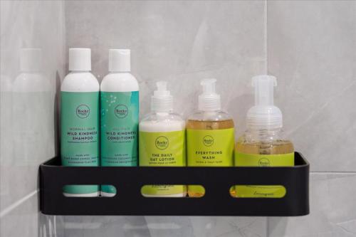 a shelf with four bottles of cleaning products on it at The Oak Hotel in Nelson
