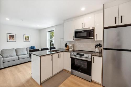 a kitchen with white cabinets and a stainless steel refrigerator at The Oak Hotel in Nelson