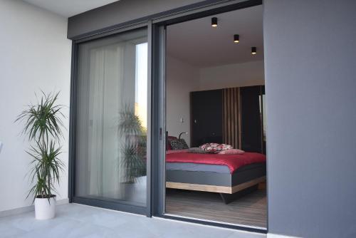 a bedroom with a bed through a glass wall at Villa M&M in Ližnjan
