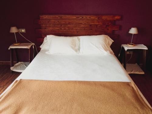 a large white bed with two nightstandiatesiatesiatesiatesiatesiatesiatesiates at Hotel Vitorio in Cudillero