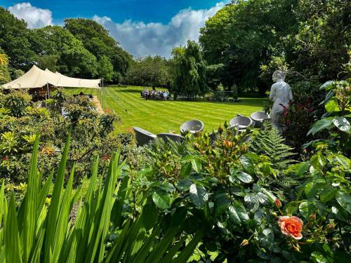 a group of chairs and a statue in a garden at Plas Dinas Country House in Caernarfon