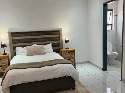 a bedroom with a large bed and a toilet at Vinview 4-bedroom holiday home in Swakopmund