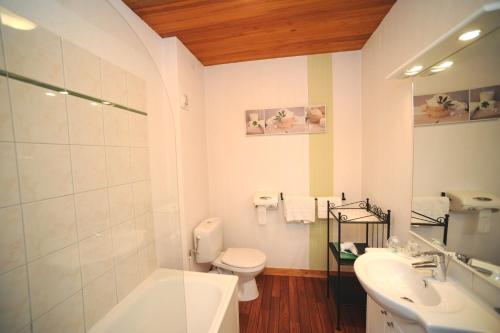a white bathroom with a toilet and a sink at Hôtel Fontaine, Morlaix in Morlaix