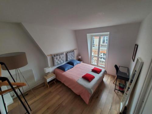 - une chambre avec un lit doté d'oreillers rouges et bleus dans l'établissement Guest room paris - R&M, à Paris