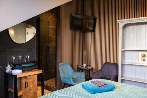 a bedroom with a bed and a sink and a mirror at Koraal - Comfortabele kamer bij B&B Gezond aan Zee - Toegang Wellnesstuin meerprijs in Ouddorp