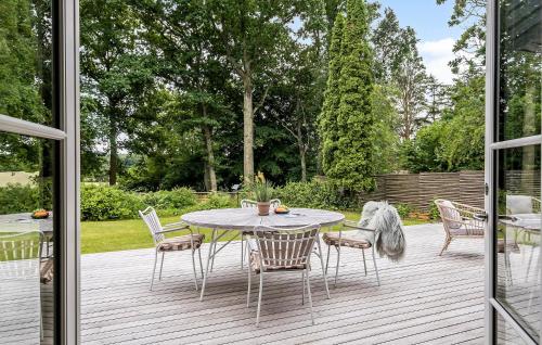 a patio with a table and chairs on a deck at Nice Home In Hornbæk With Wifi in Hornbæk