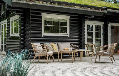 a wooden patio with a table and two chairs at Nice Home In Hornbæk With Wifi in Hornbæk