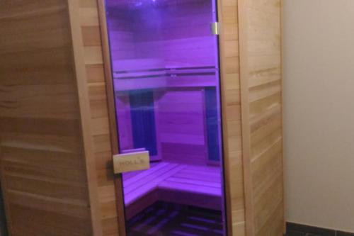 un ascenseur avec des lumières violettes dans une pièce dans l'établissement Maison contemporaine vue mer et sauna, à Plouézec