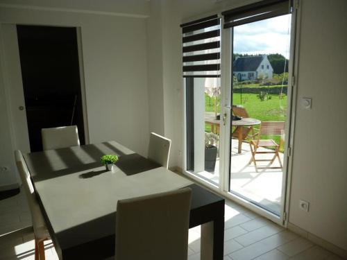 - une table à manger avec vue sur le patio dans l'établissement Maison contemporaine vue mer et sauna, à Plouézec