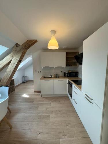 une grande cuisine avec des placards blancs et un plafond dans l'établissement Le Petit Nid de Colmar - Parking privé, à Colmar