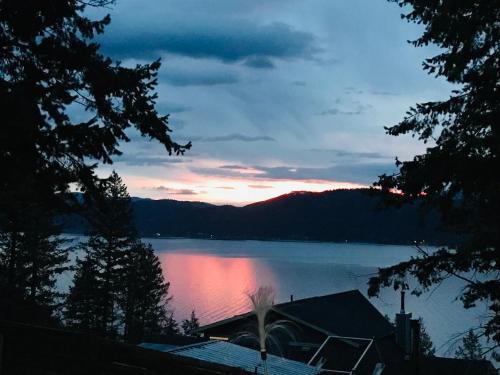 a view of a lake with a sunset in the background at Blarney Place Retreat in Vernon