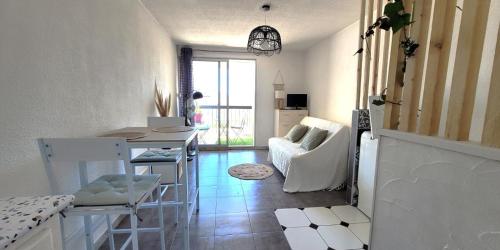 un salon avec une table et une cuisine dans l'établissement Studio Port du Cap d'Agde, au Cap d'Agde