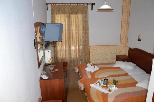 a hotel room with two beds and a tv at Hotel Hani Zisi in Chania