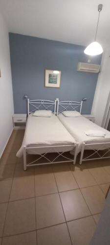 a bed in a room with a blue wall at Nikolaki Rooms in Porto Rafti