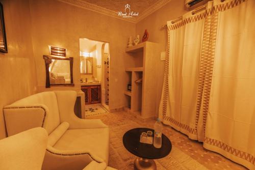 a living room with a chair and a shower at Riad Aslal in Marrakech