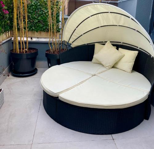 a wicker bench sitting on a patio at Aura Apartment und Spa Oberhausen in Oberhausen