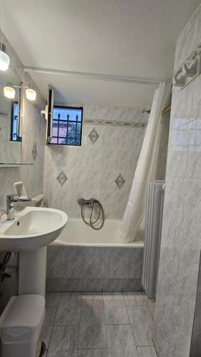 a bathroom with a sink and a tub and a toilet at Sunny Home in Naxos Chora