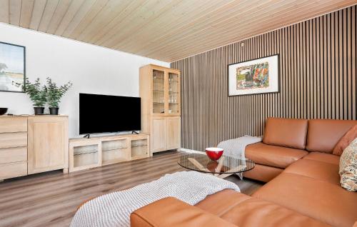 a living room with a couch and a flat screen tv at 3 Bedroom Awesome Home In Videbæk in Videbæk