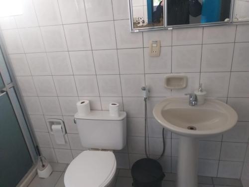 a white bathroom with a toilet and a sink at casa das flores in Canoas
