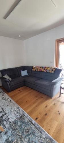 a blue couch in a living room with a wooden floor at Vila Zavino in Branik