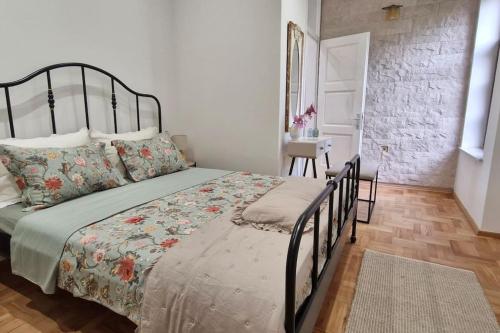 a bedroom with a large bed and a table at Mala Lu Central Apartment in Varaždin