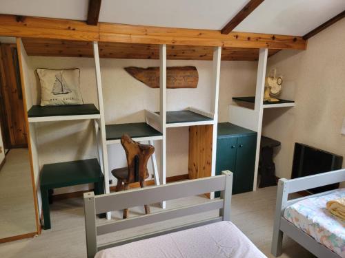 - une chambre avec un lit et une chambre avec des étagères dans l'établissement l'Oustalot, à Lanton