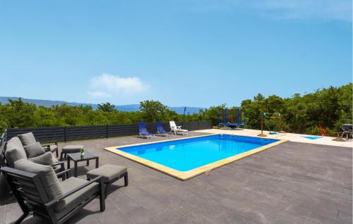 a patio with a pool and chairs and a swimming pool at 2 Bedroom Awesome Home In Polje in Polje