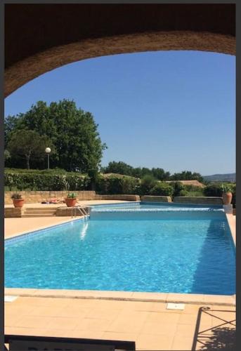 une grande piscine bleue avec une arche dans l'établissement Maisonnette en Ardèche, à Saint-Martin-dʼArdèche