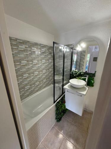 une salle de bain avec un lavabo et une baignoire et un lavabo dans l'établissement Maisonnette en Ardèche, à Saint-Martin-dʼArdèche