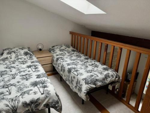 une chambre avec un lit et une balustrade en bois dans l'établissement Maisonnette en Ardèche, à Saint-Martin-dʼArdèche