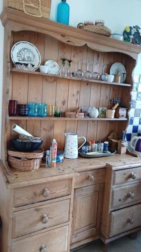 d'une armoire en bois avec des assiettes et de la vaisselle. dans l'établissement A 2 pas de la mer, à Hautot-sur-Mer