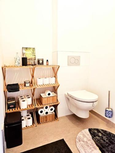 La salle de bains est pourvue de toilettes et d'une étagère avec des articles de toilette. dans l'établissement Chic appartement en plein Paris, à Paris