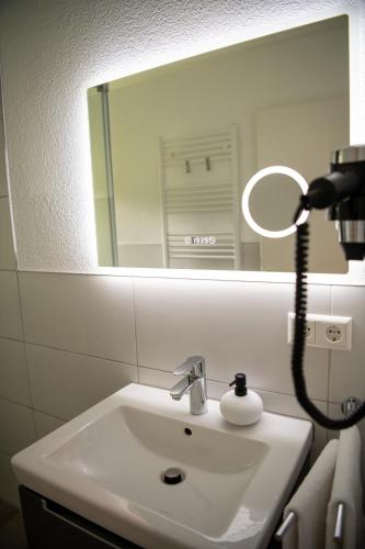 a bathroom with a white sink and a mirror at Renatas Ferienwohnung Stanel in Sasbachwalden