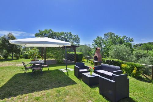 a patio with an umbrella and a table and chairs at Da Maria - Happy Rentals in Murlo