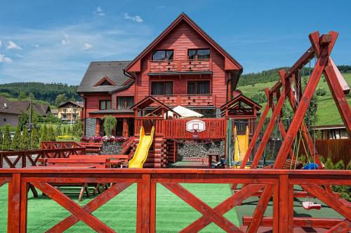 a house with a playground in front of it at Winter & Summer Resort in Ždiar