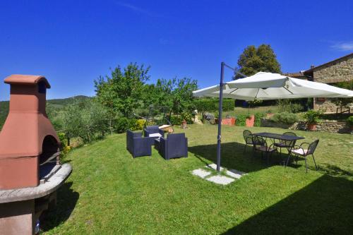 a patio with an umbrella and a table and chairs at Da Maria - Happy Rentals in Murlo
