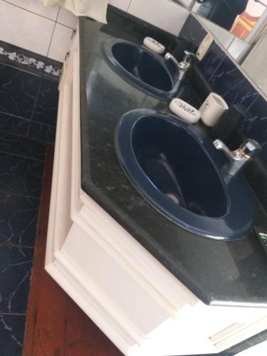 a bathroom with two toilets in a black counter at casa das flores in Canoas