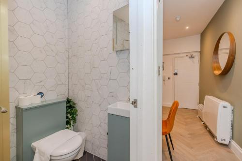 a bathroom with a toilet and a sink and a mirror at 2 Bedroom Flat Next To Brighton Beach in Brighton & Hove