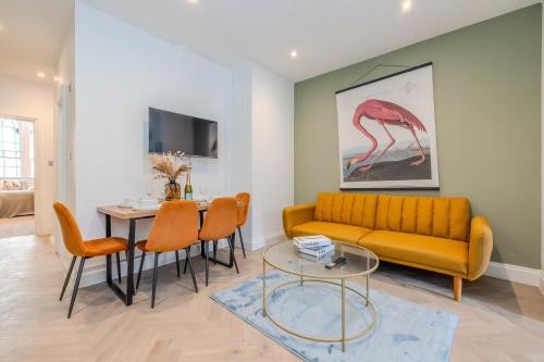 a living room with a yellow couch and a table at 2 Bedroom Flat Next To Brighton Beach in Brighton & Hove