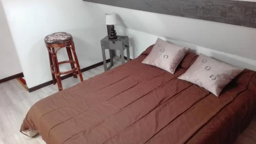 - une chambre avec un lit, une table et un tabouret dans l'établissement Gite Feugas, à Assat