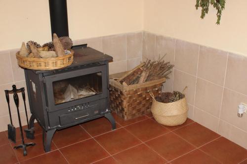 a stove in a room with baskets on the floor at Herdade di Luce in Daporta