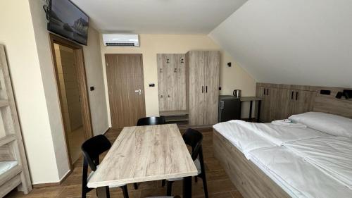 a bedroom with a wooden table and a bed at Ubytování U Pupka in Vrbovec