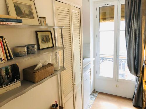 une pièce avec des étagères et une porte avec une fenêtre dans l'établissement Studio Montmartre, à Paris