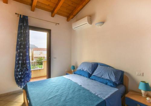 a bedroom with a blue bed and a window at Casa Elisa in Viddalba