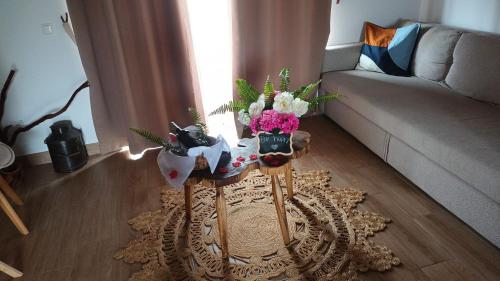 a living room with a table with flowers on it at Casas da Quinta in Santa Cruz das Flores