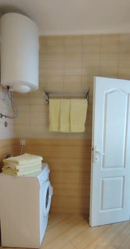 a bathroom with a washing machine and towels on a wall at Crypto Hills Montenegro in Herceg-Novi