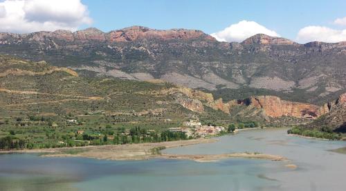 a view of a river with mountains in the background at La Noguera Camping in Sant Llorenç de Montgai