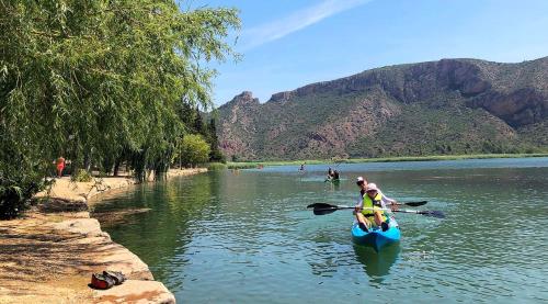 a couple of people in a kayak on a river at La Noguera Camping in Sant Llorenç de Montgai