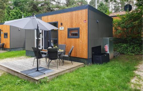 a small house with a table and an umbrella at Tiny Haus 49 Am Brombachsee in Pleinfeld