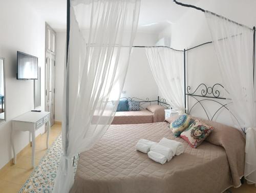 a bedroom with two beds with white curtains at Cristalli di Keli in Santa Elisabetta